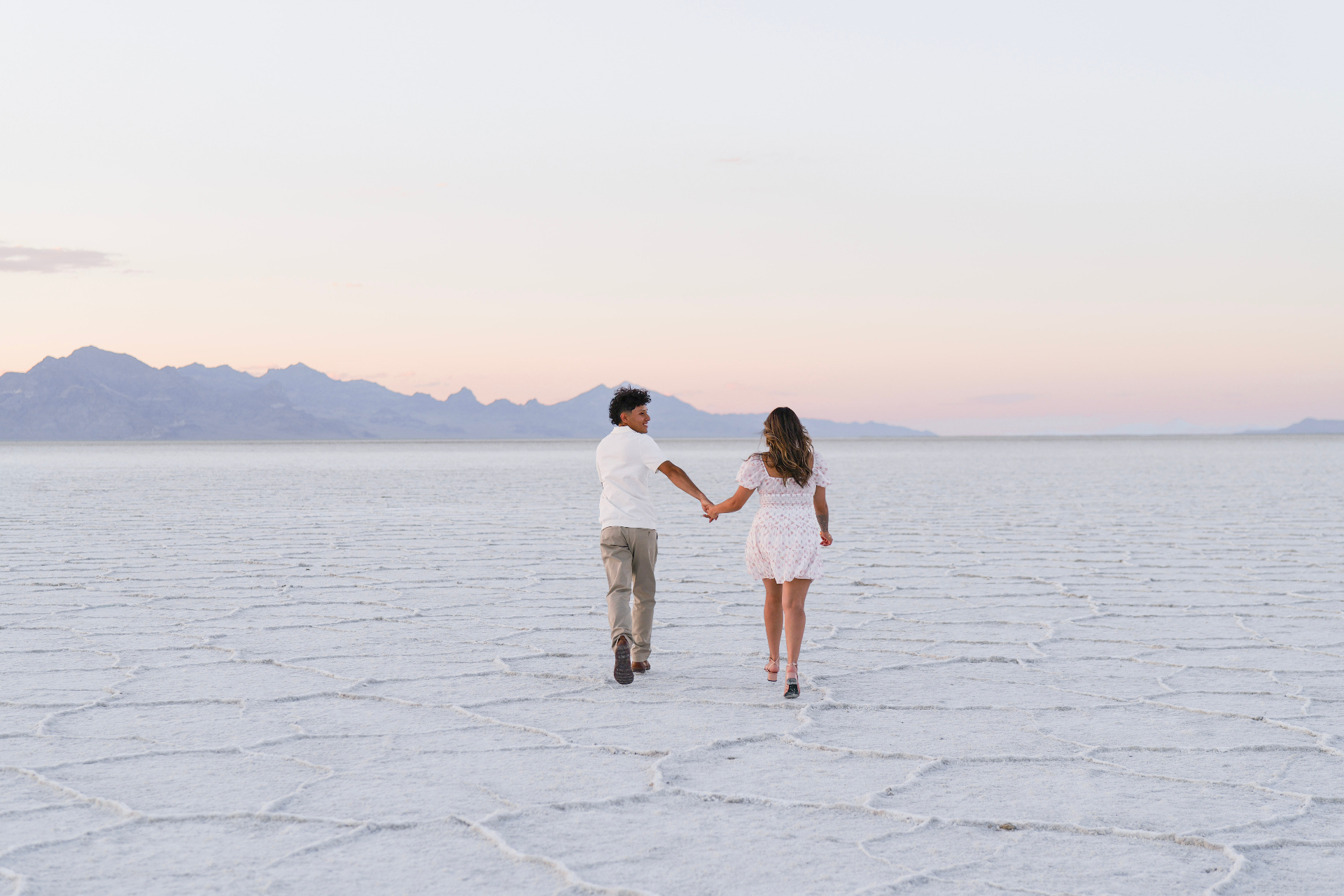 Couple looking back while walking on the salt flats